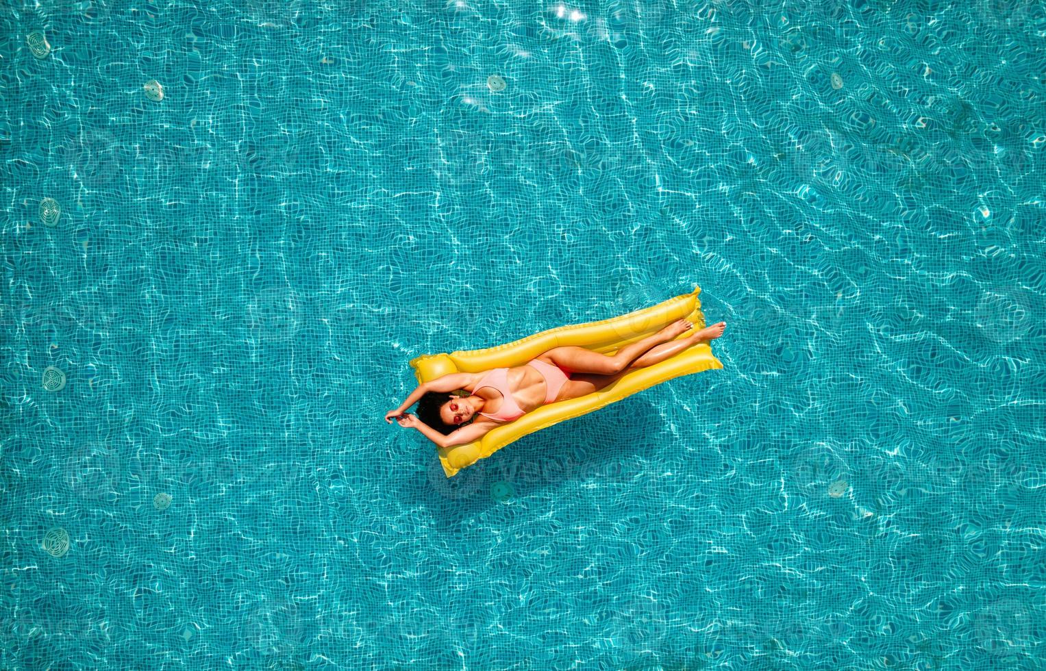 fille dans maillot de bain qui bronzer dans une nager bassin photo