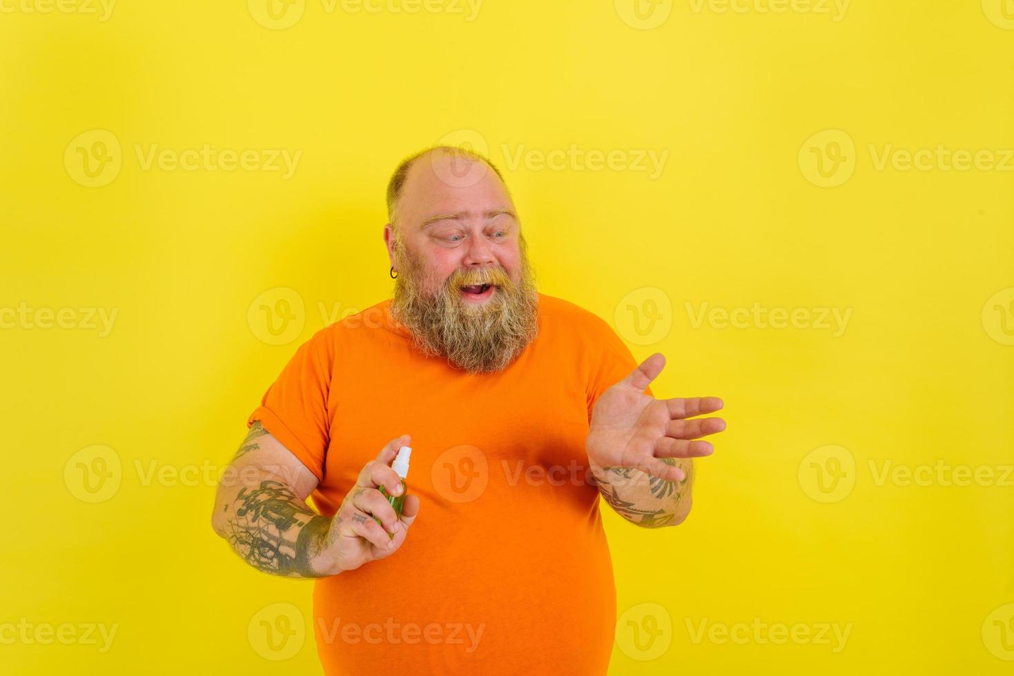 content homme avec barbe et tatouages détient une mains nettoyeur contre covid19 photo