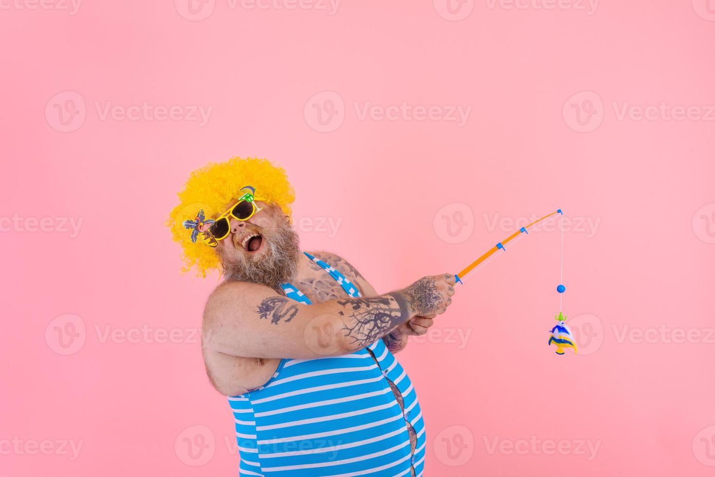 graisse content homme avec barbe et des lunettes de soleil avoir amusement avec le pêche pôle photo