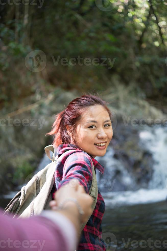 jeune couple aventure femme guidant l'homme dans le concept de voyage de la forêt. photo