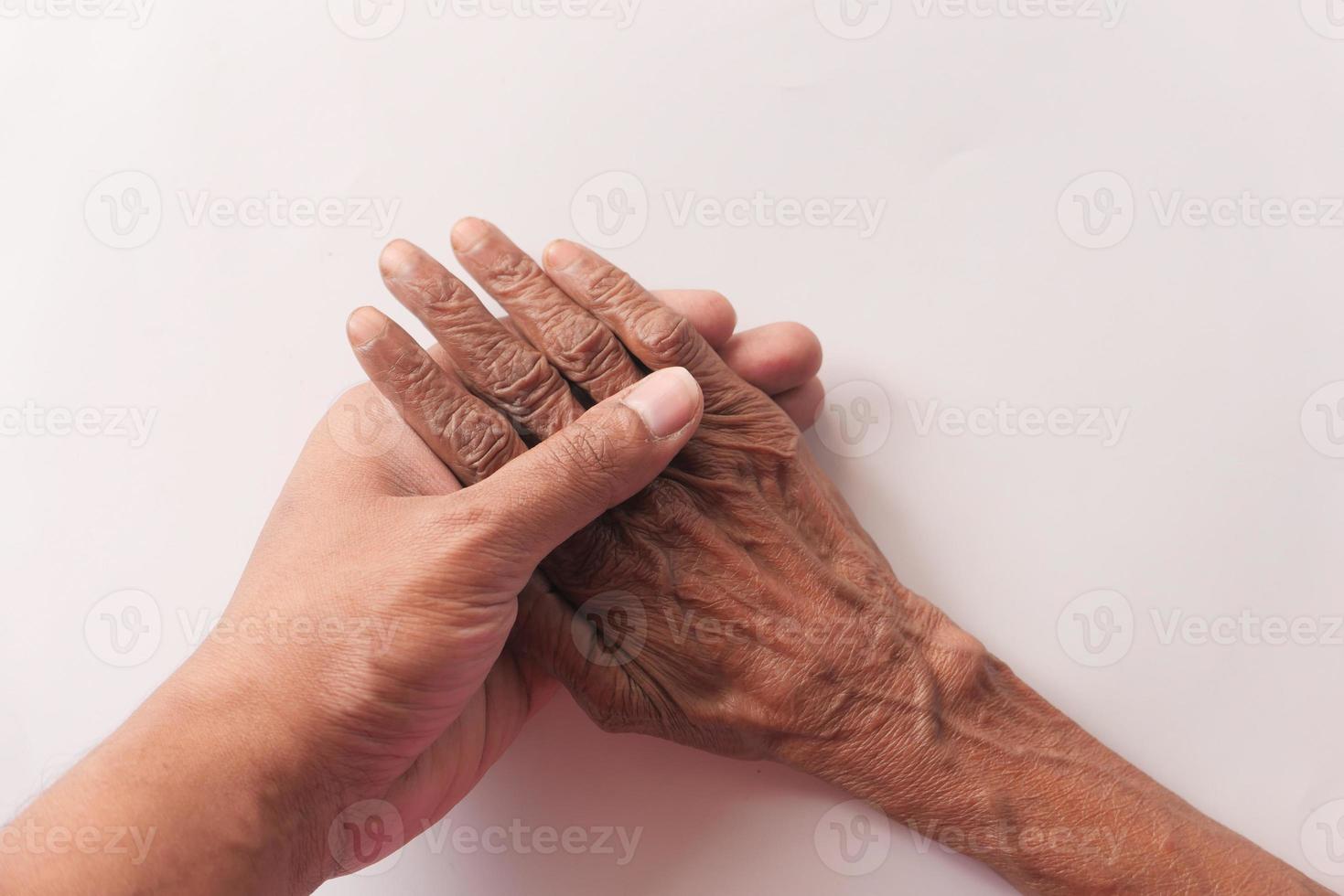 jeune tenant la main d'une personne âgée photo