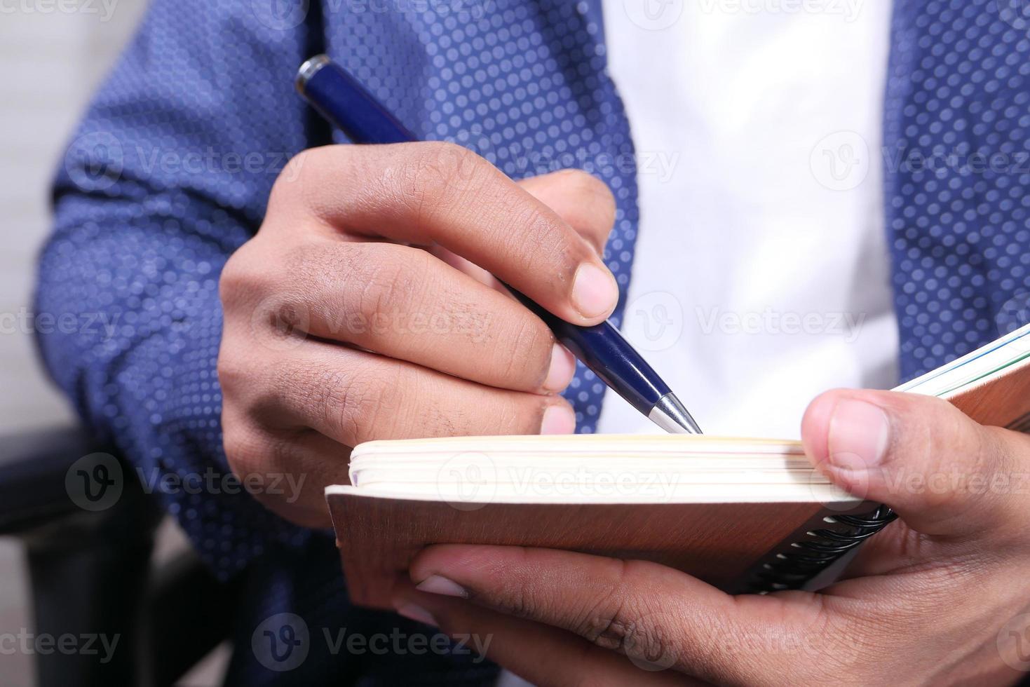 homme écrivant dans un bloc-notes photo