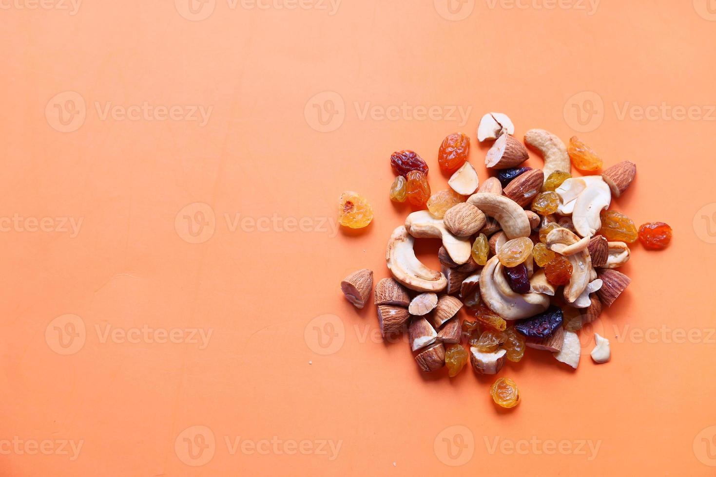 Gros plan de nombreuses noix mélangées sur fond orange photo