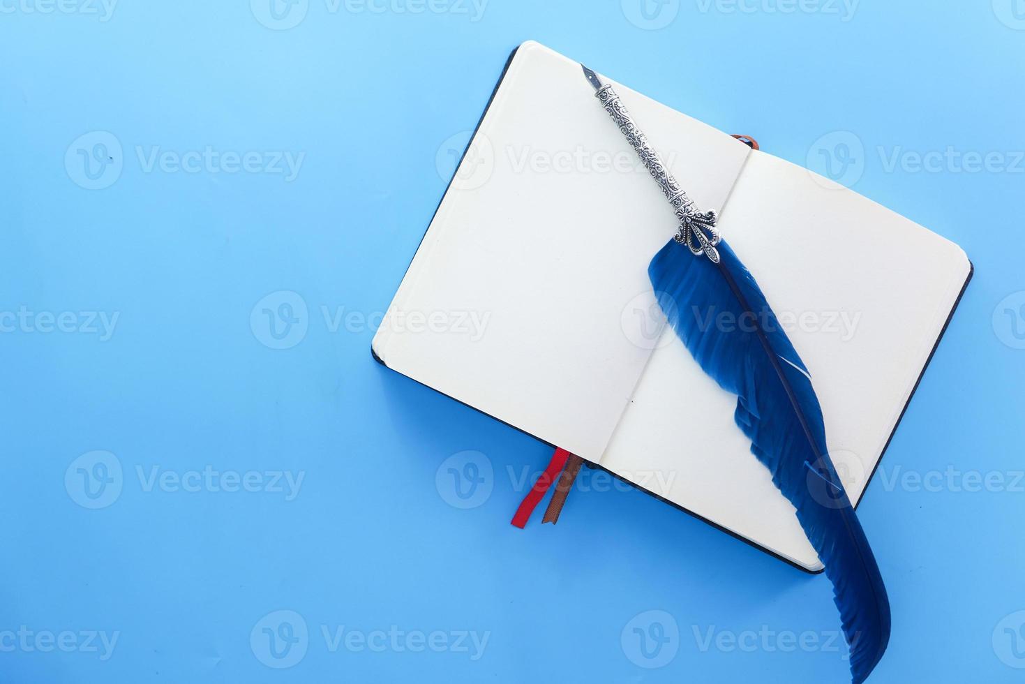 livre ouvert et vieux stylo plume sur fond bleu photo