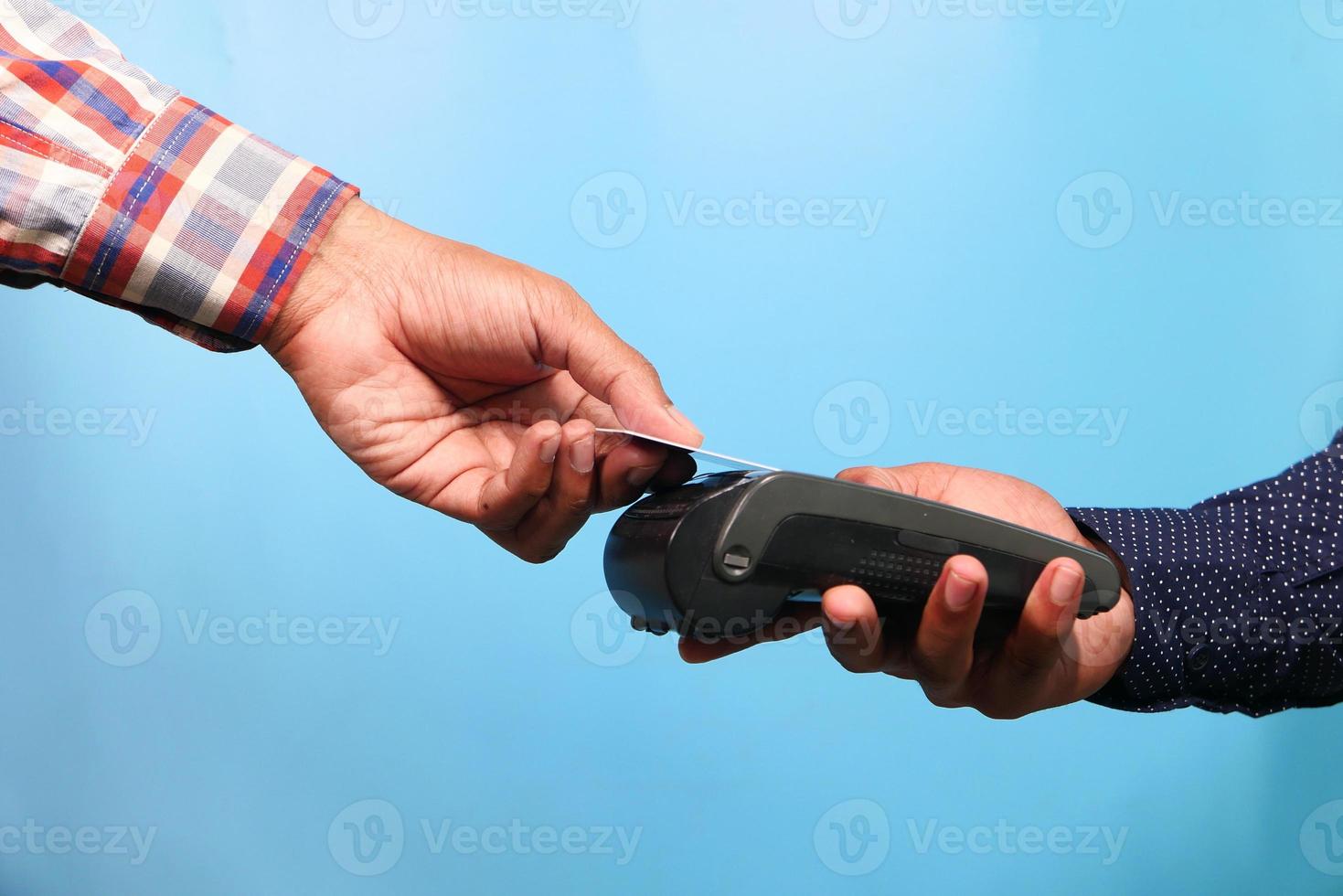 homme payant par carte de crédit sur fond bleu photo