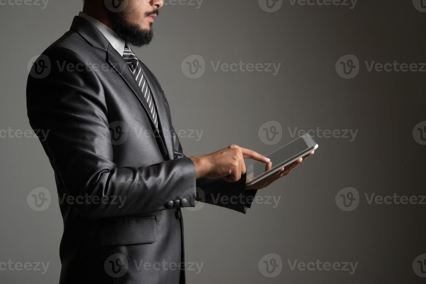homme d & # 39; affaires tenant et touchant sur tablette numérique et à la recherche sur un écran vide photo
