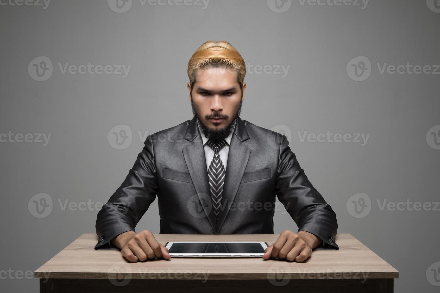 beau jeune homme d'affaires travaillant avec le pavé tactile alors qu'il était assis au bureau photo