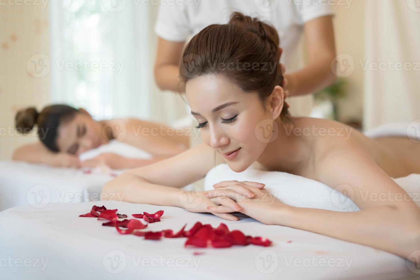 belle jeune femme avec massage sain dans un salon spa photo