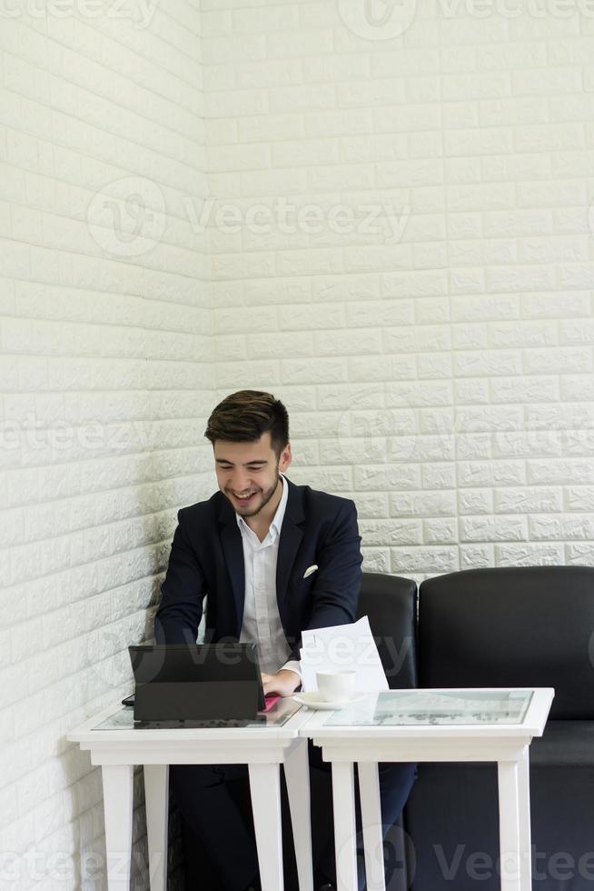 jeune homme d'affaires ayant une pause-café travaillant sur ordinateur portable photo