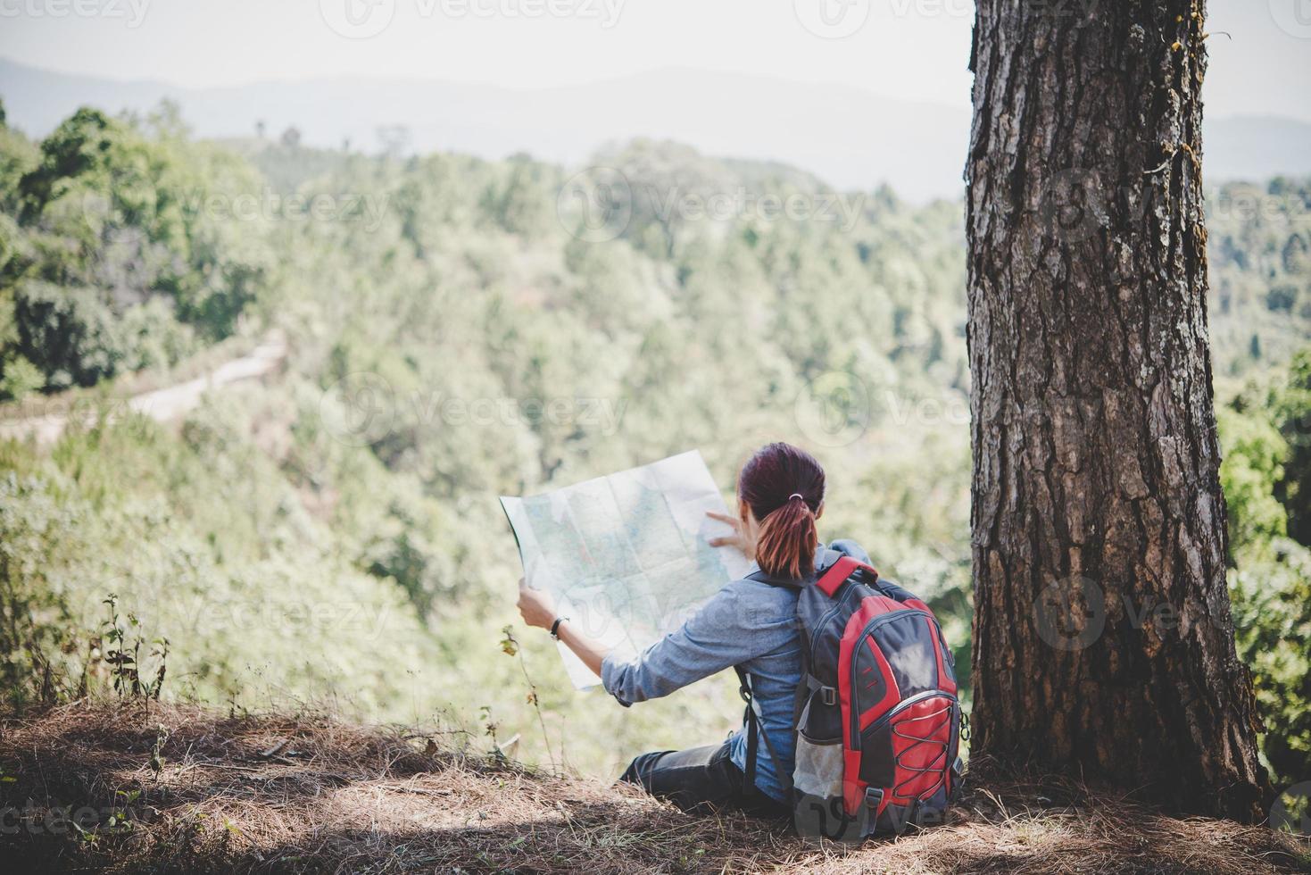 Randonneur jeune femme lisant une carte lors d'une randonnée photo