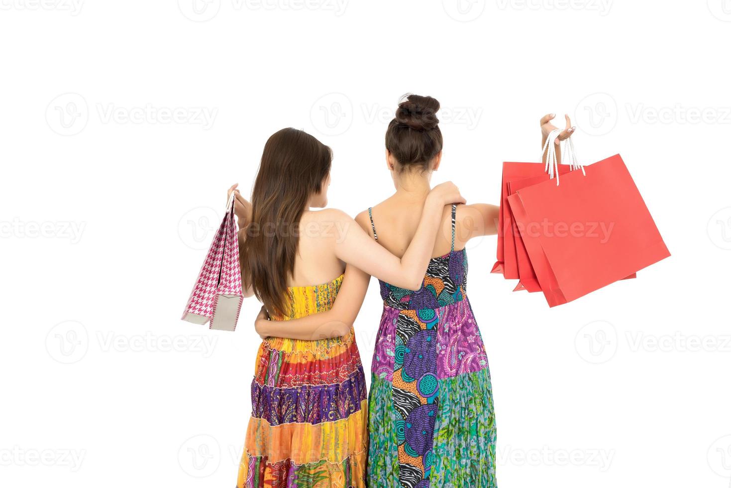 Deux jeunes femmes portant des sacs à provisions isolés sur fond blanc photo