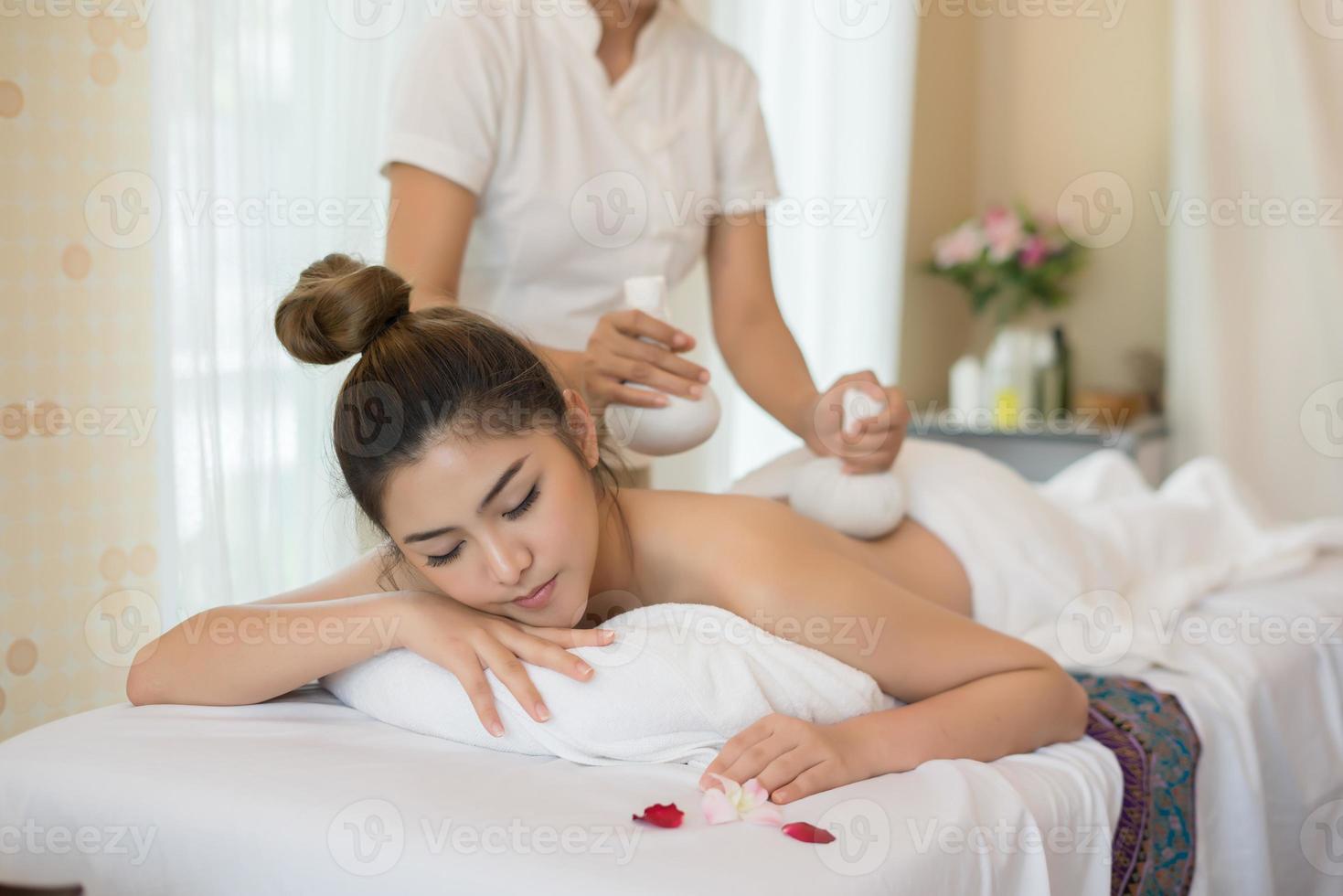 belle jeune femme avec massage sain dans un salon spa photo