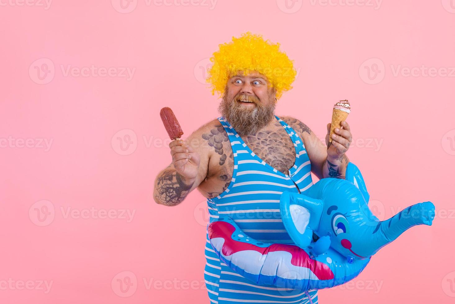 graisse homme avec barbe et perruque mange une popsicle et un crème glacée photo