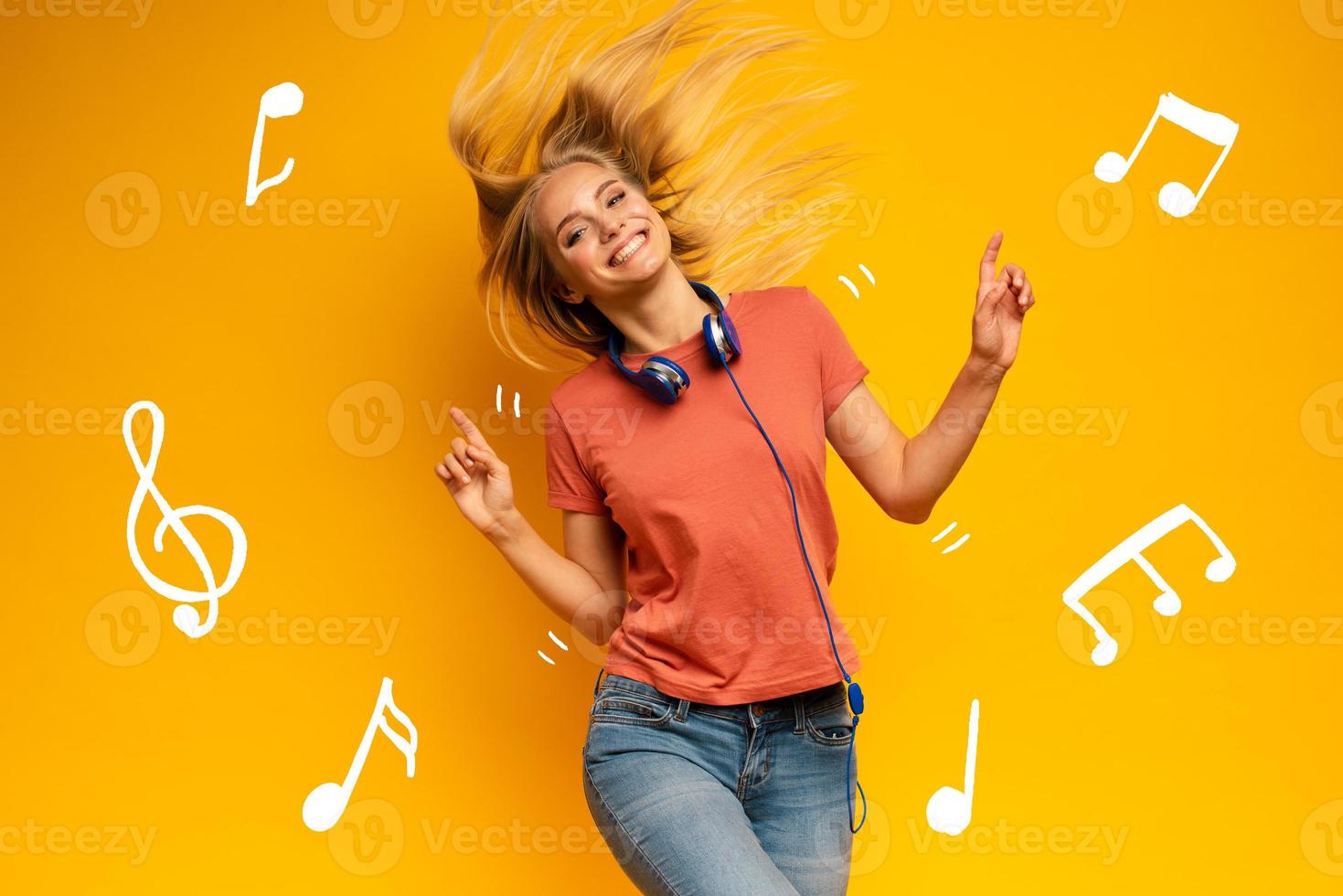 blond fille écoute à la musique avec casque. joyeux expression sur Jaune Contexte photo
