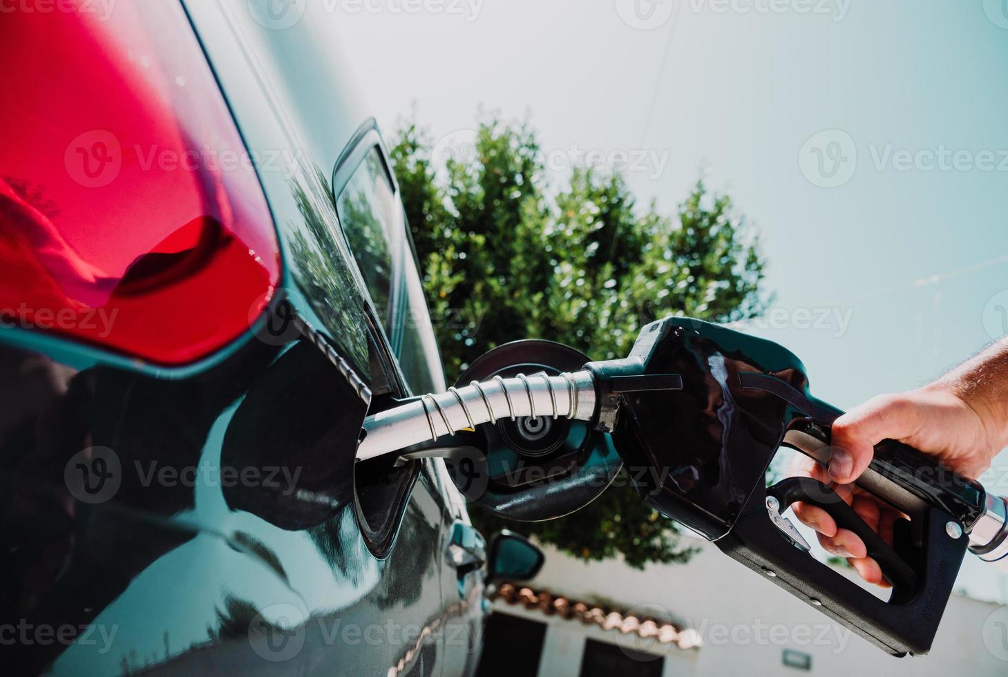 carburant pompe remplir une réservoir de une voiture dans une station photo