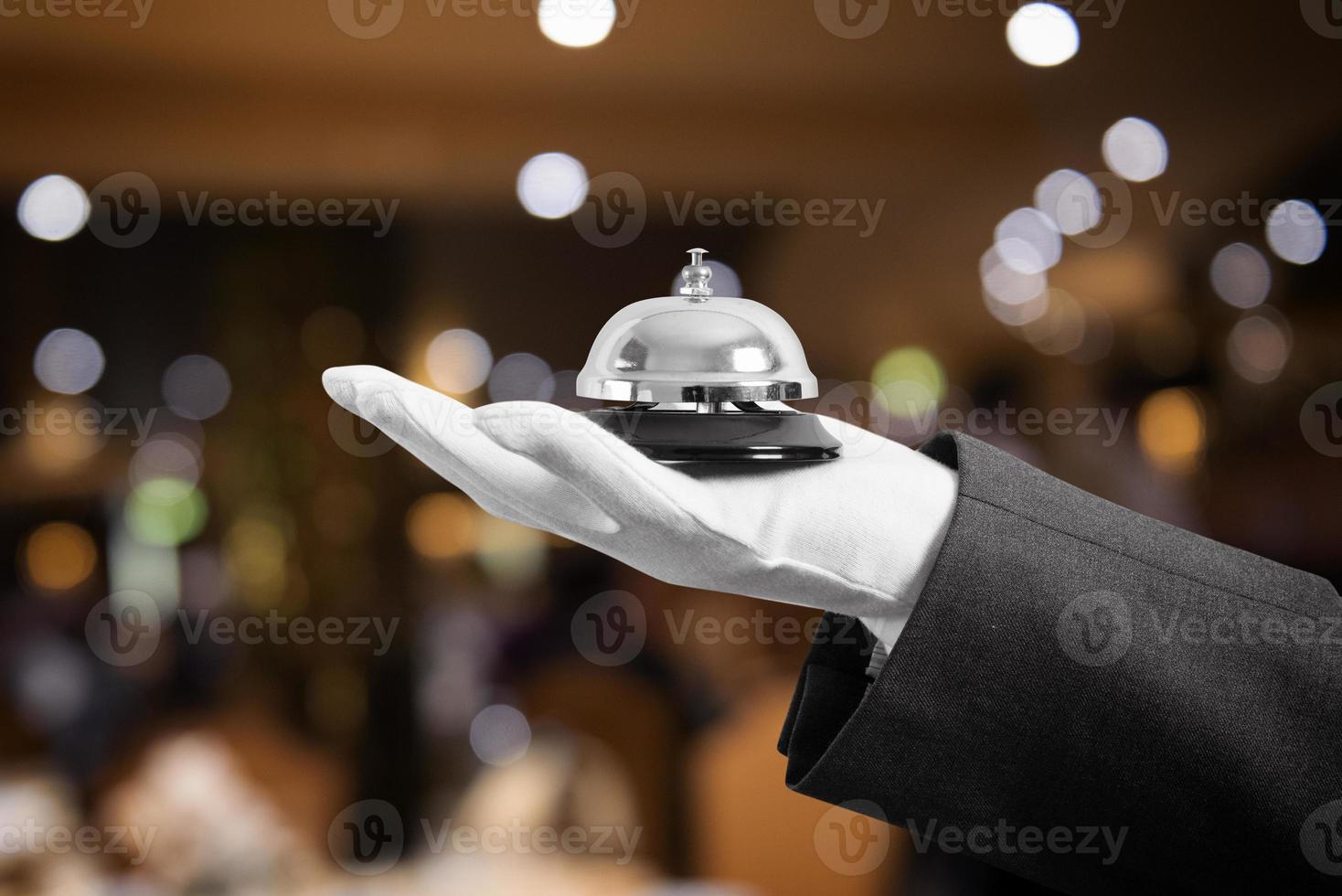 serveur avec cloche dans main. concept de premier classe un service dans votre restaurateur. photo