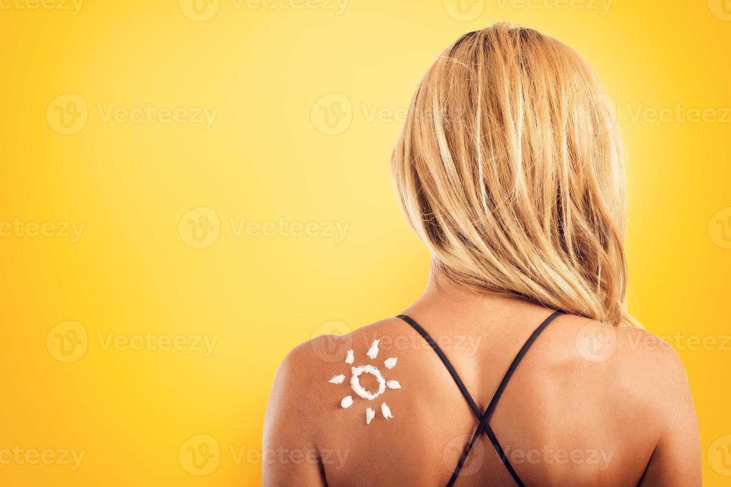 fille dans maillot de bain avec une Soleil fabriqué avec crème solaire. photo