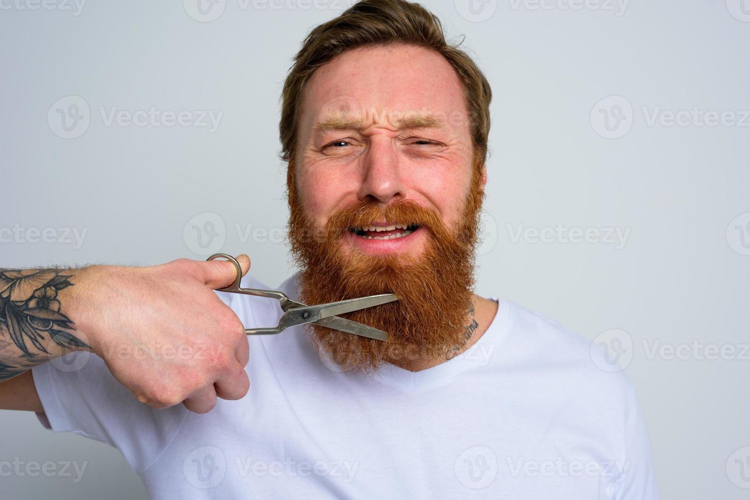 malheureux homme avec les ciseaux biches ne pas vouloir à Couper le barbe photo