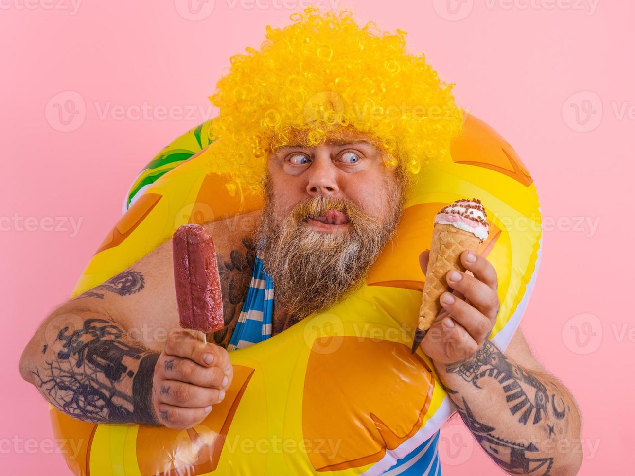 graisse homme avec barbe et perruque mange une popsicle et un crème glacée photo