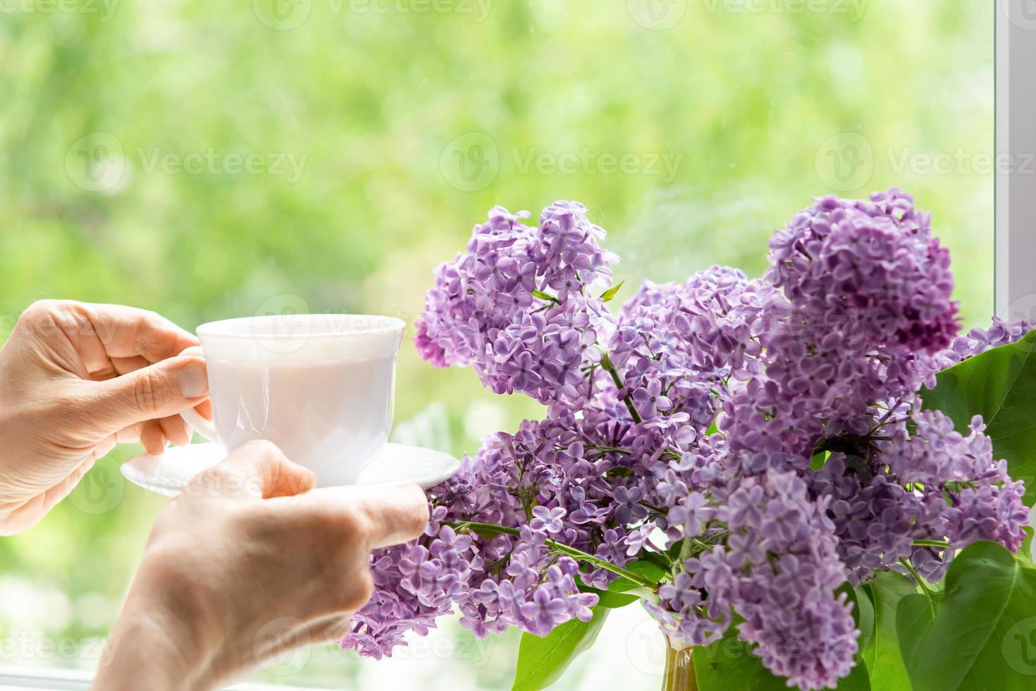 Accueil intérieur avec une bouquet de épanouissement lilas fleurs sur le la fenêtre. photo