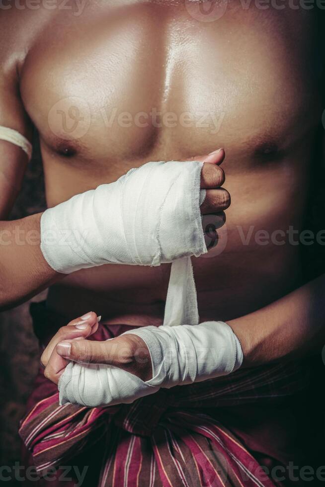 le boxeur s'est assis sur la pierre, a noué le ruban autour de sa main, se préparant à se battre. photo