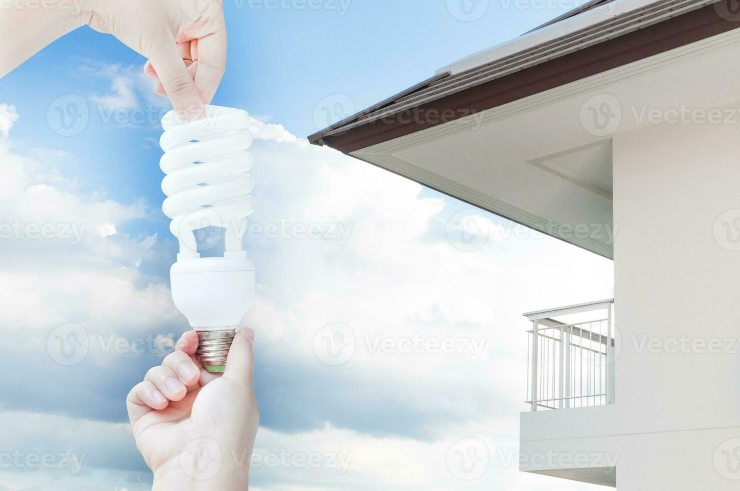 énergie économie concept, femme main en portant lumière ampoule sur maison arrière-plan, idées lumière ampoule dans le main photo