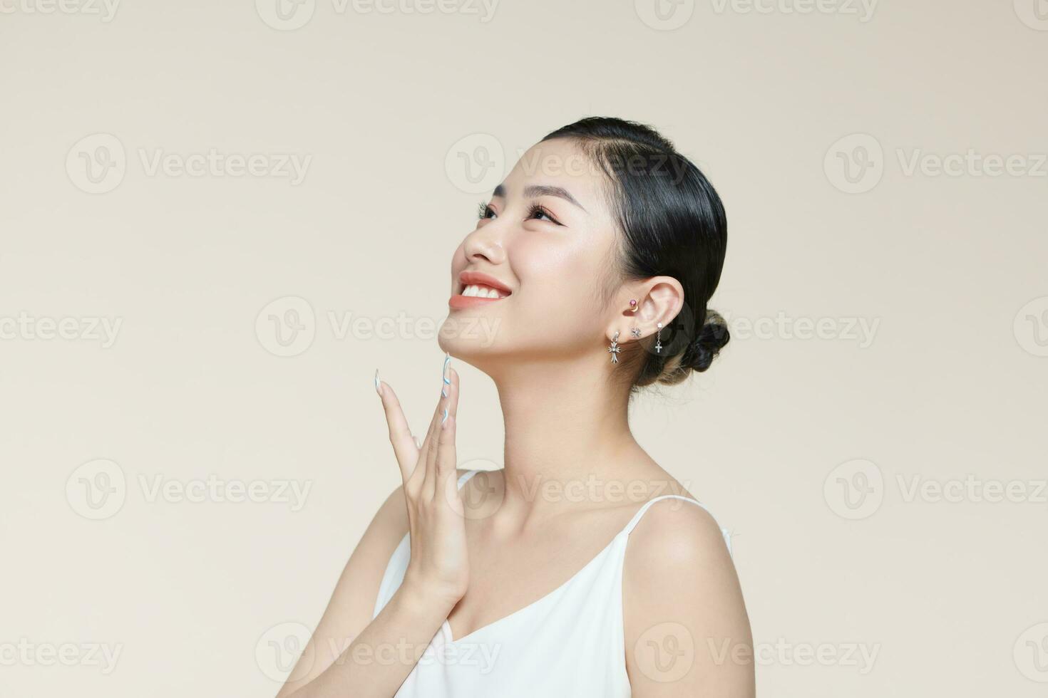femme avec parfait peau émouvant menton isolé sur beige photo