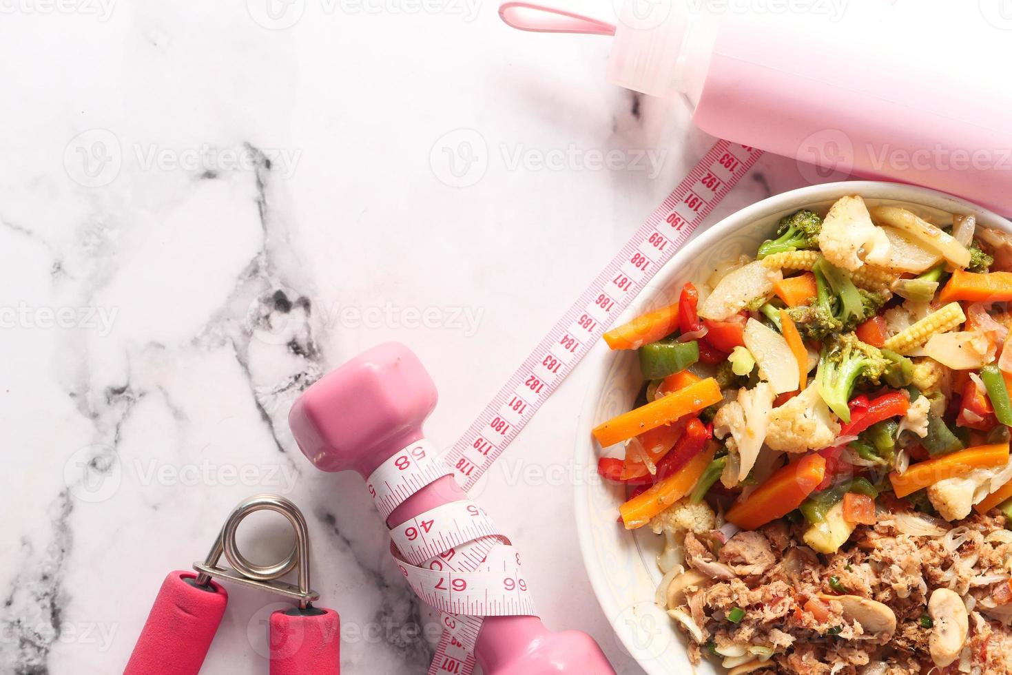 concept de remise en forme avec haltère, légumes frais et ruban à mesurer photo