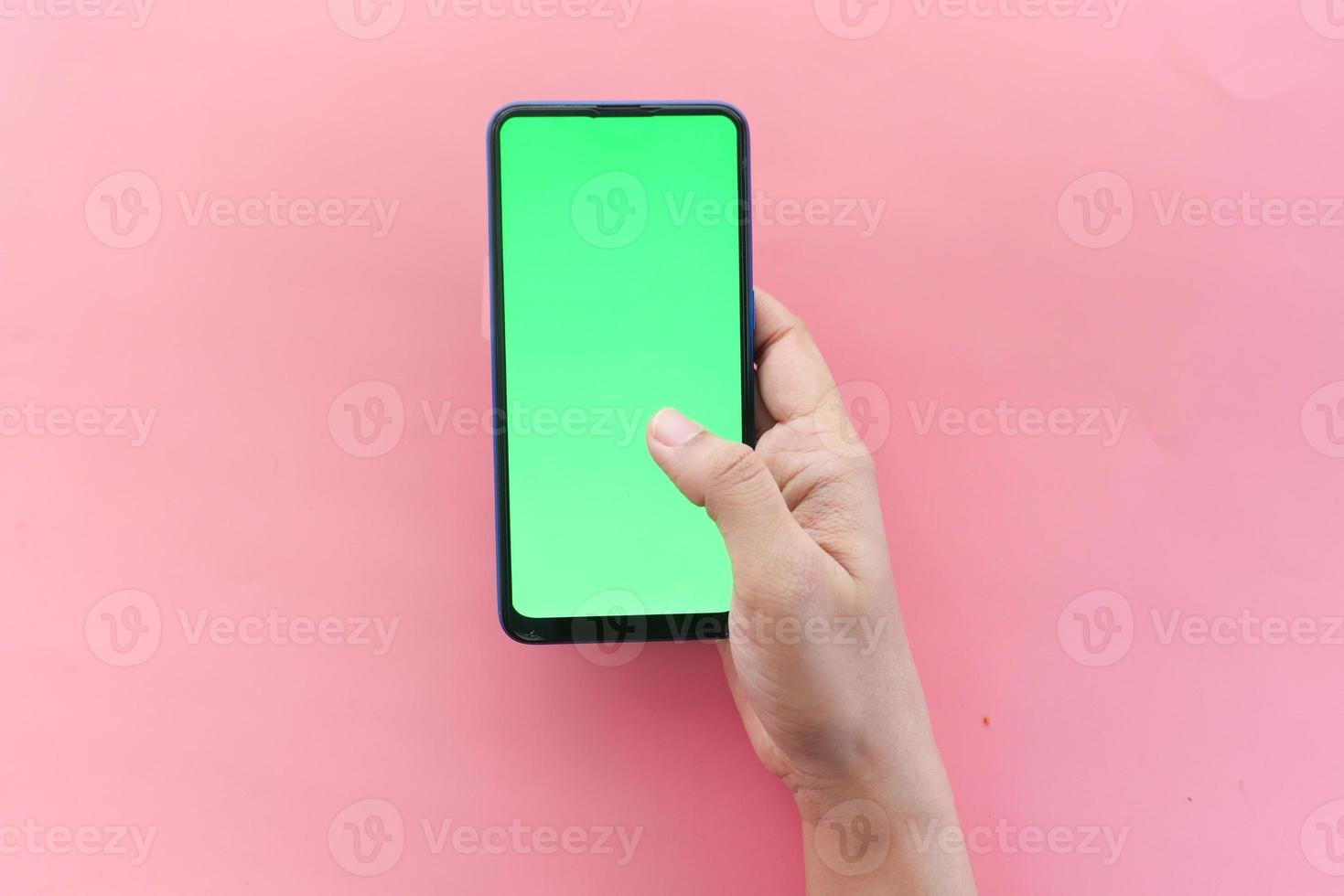 Vue de dessus d'un téléphone intelligent à écran vert sur fond rose photo