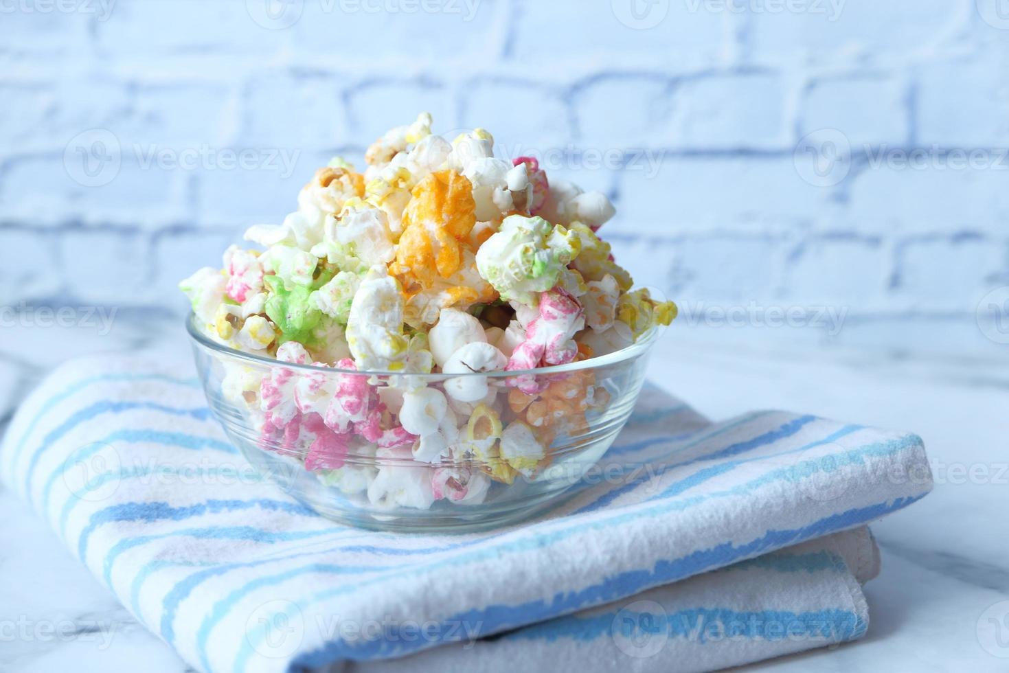 Pop-corn coloré dans un bol sur un bureau en bois photo