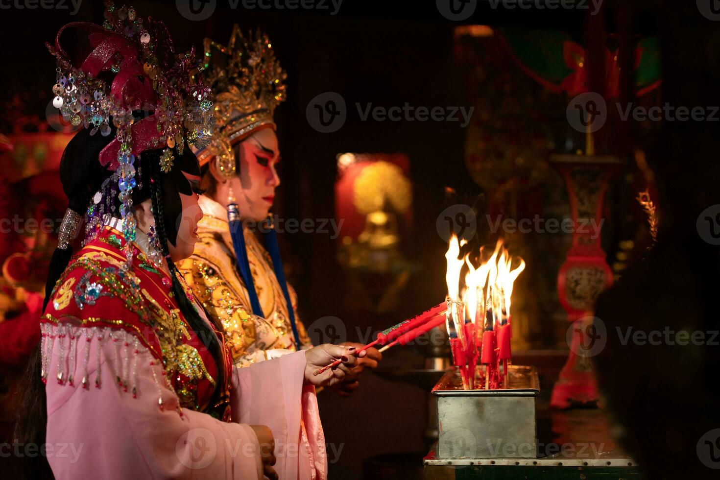 Masculin et femelle chinois opéra acteurs lumière une bougie à prier hommage à le dieux à améliorer le la prospérité pour toi même sur le occasion photo