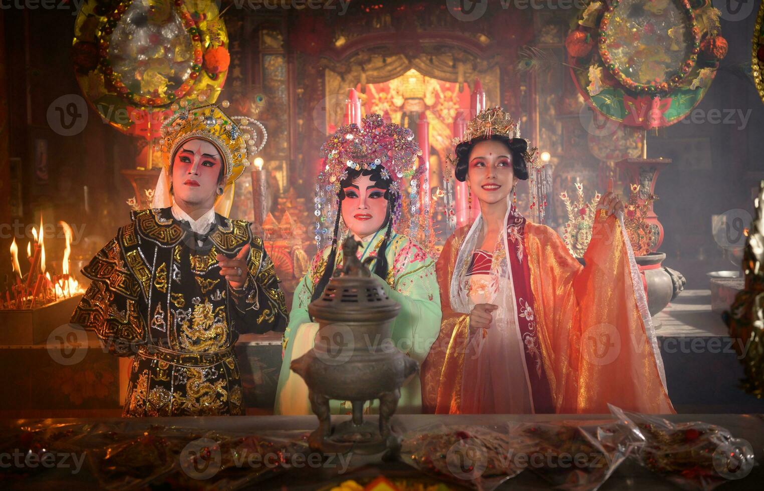 Masculin et femelle chinois opéra acteurs lumière une bougie à prier hommage à le dieux à améliorer le la prospérité pour toi même sur le occasion photo