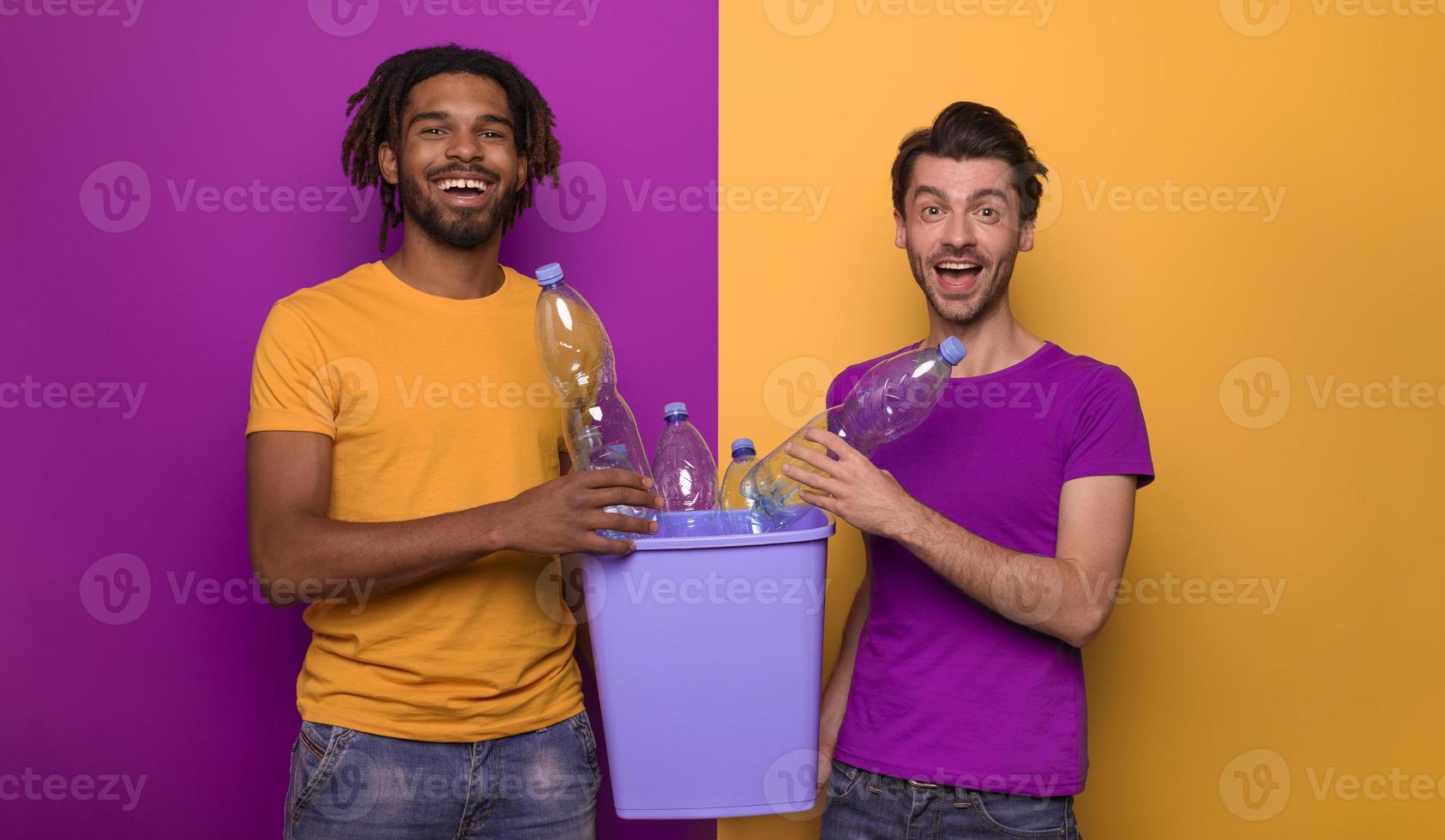 copains tenir une Plastique récipient avec bouteilles plus de Jaune et violet couleur. concept de écologie, conservation, recyclage et durabilité photo