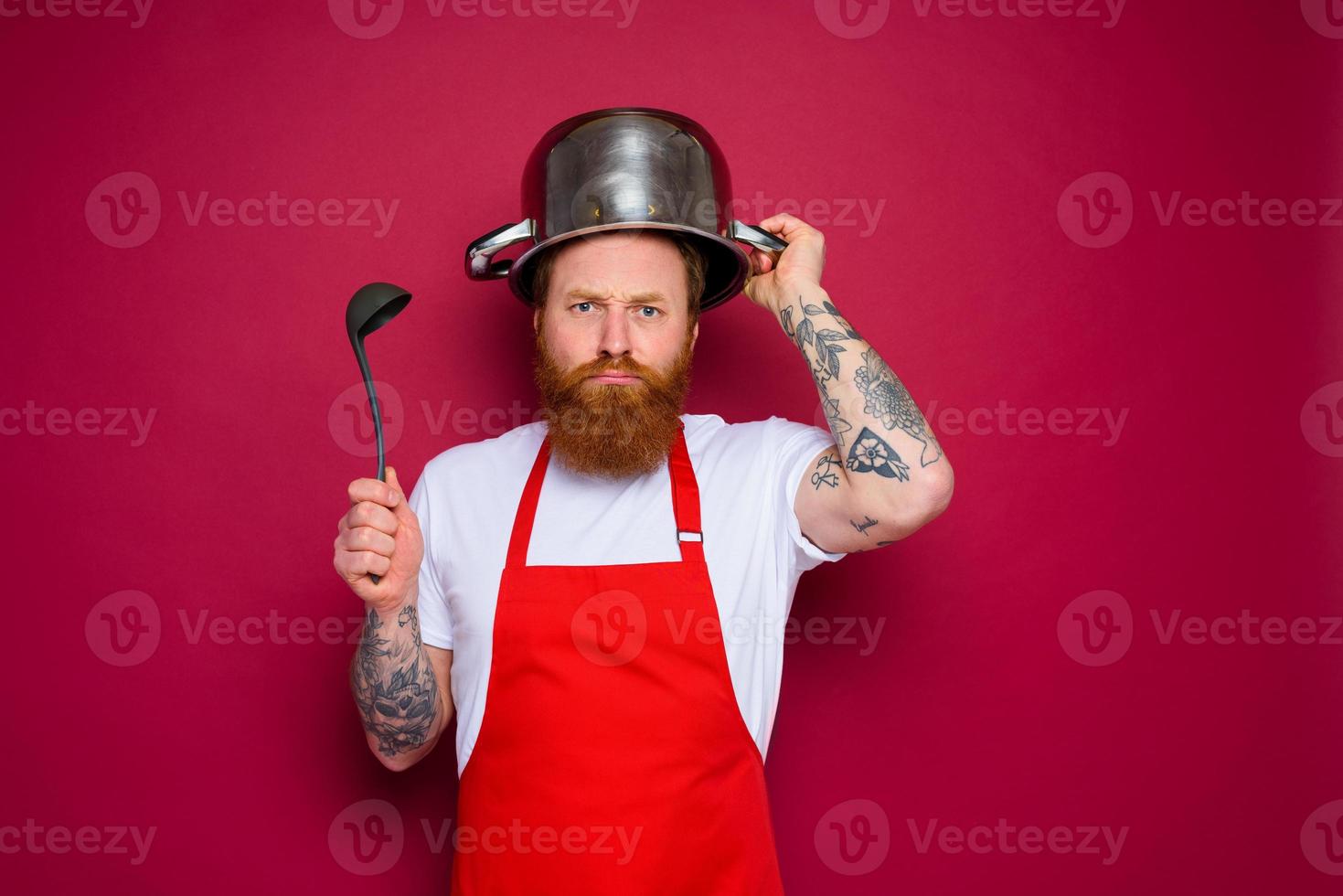 malheureux chef avec barbe et rouge tablier pièces avec pot photo