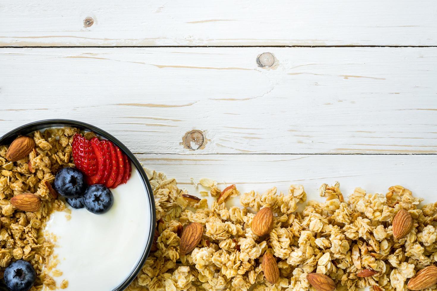 bol de granola avec yaourt, Frais baies, fraise sur bois table avec espace. photo