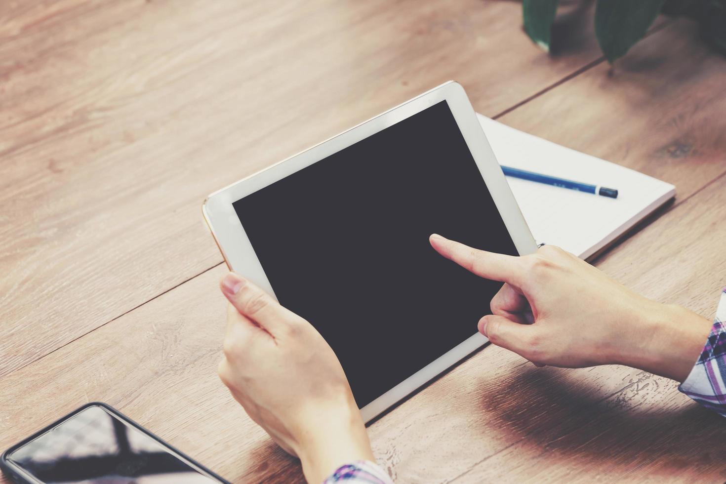 main femme en utilisant tablette ordinateur sur en bois table avec ancien tonique. photo