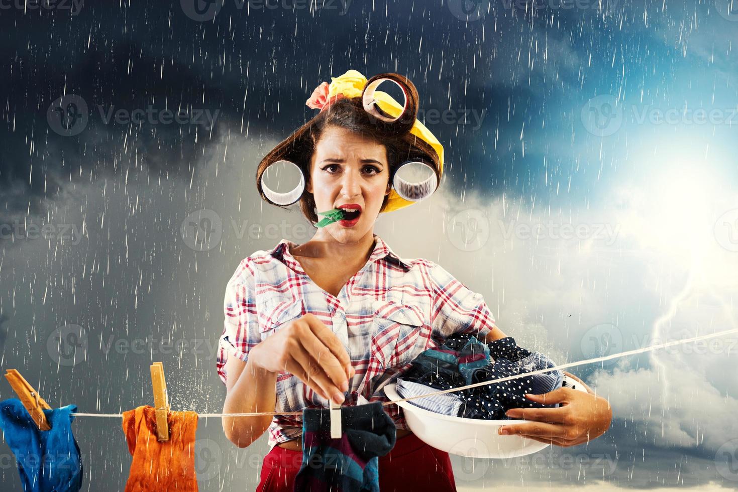 malheureux femme au foyer bloque vêtements et il départs à pluie photo