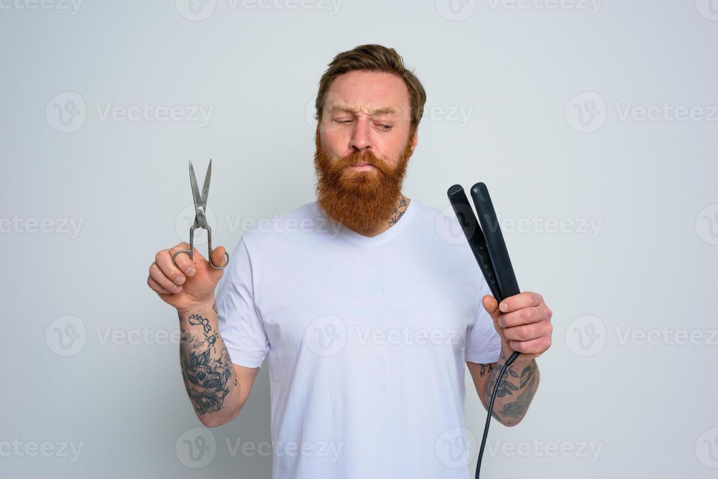 indécis homme avec les ciseaux et lisseur est prêt à travail avec cheveux photo