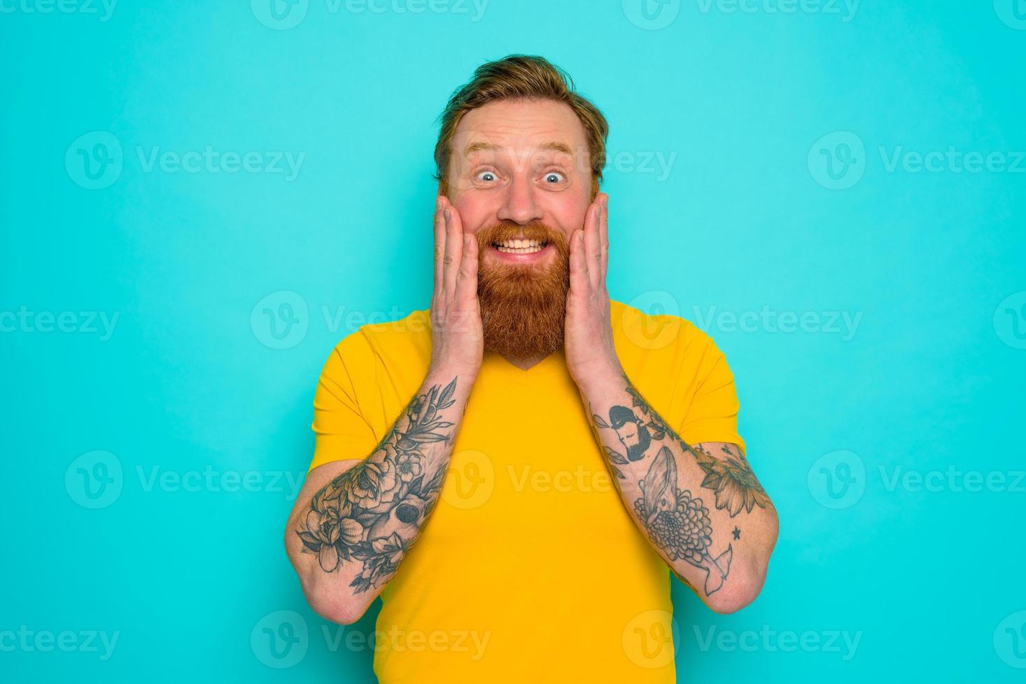 homme avec Jaune T-shirt et barbe est très content photo