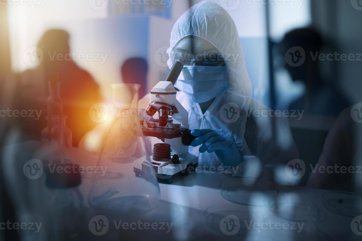 médecin dans le laboratoire analyses échantillons en dessous de une microscope. pharmaceutique traitement concept. photo
