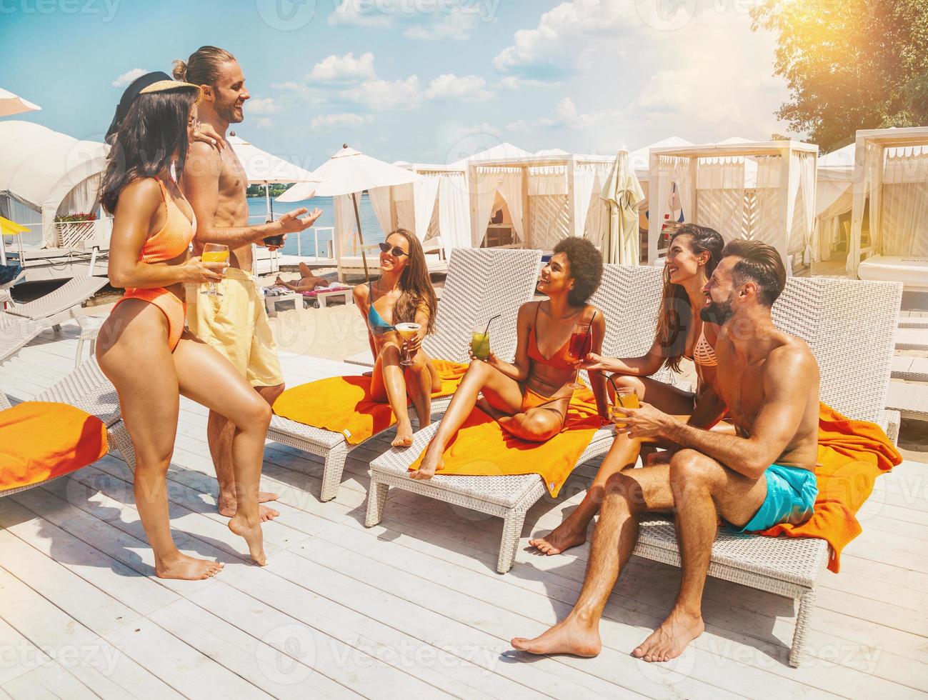 groupe de copains avec maillot de bain boisson une cocktail dans une plage endroit photo