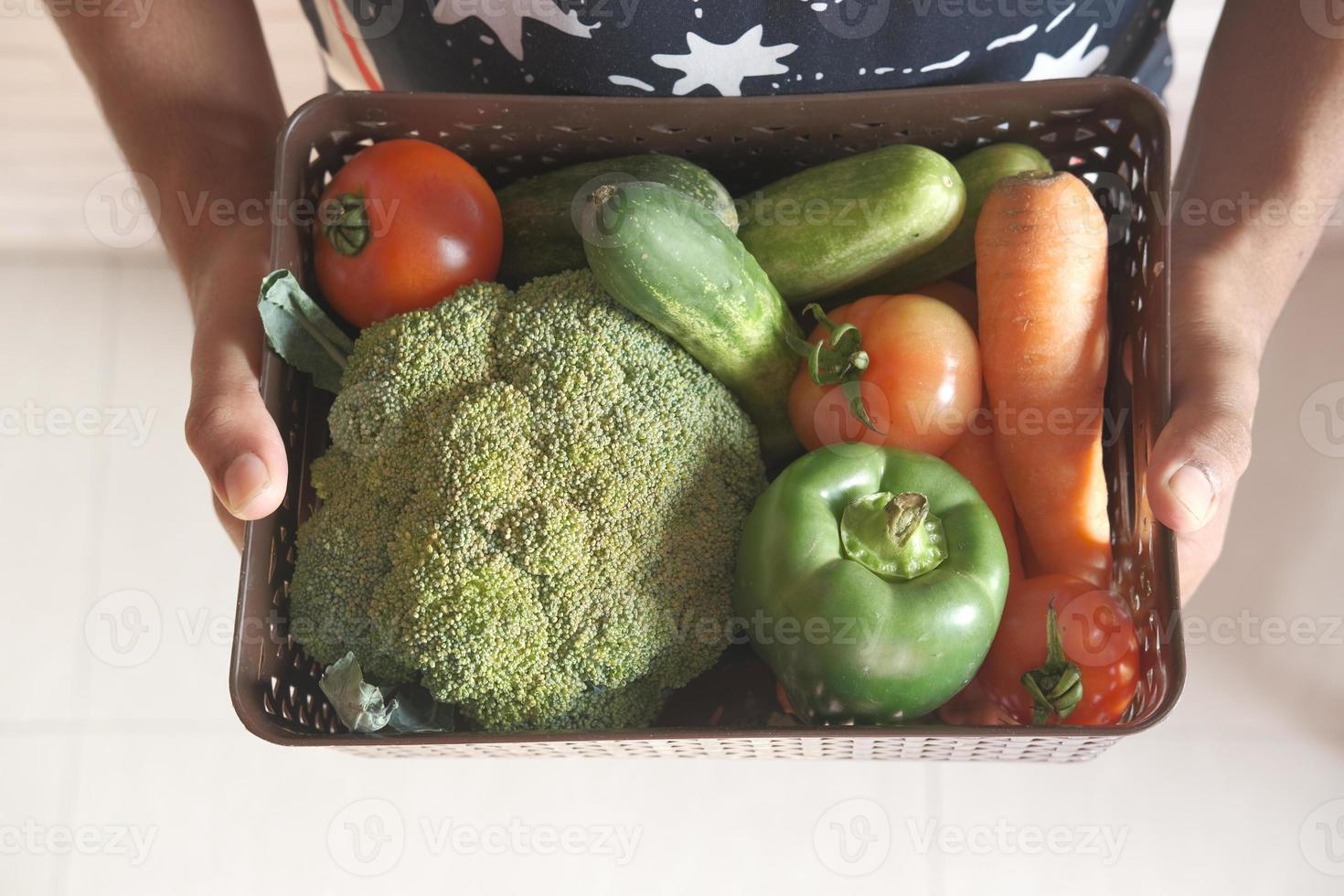 tenant un panier de légumes photo