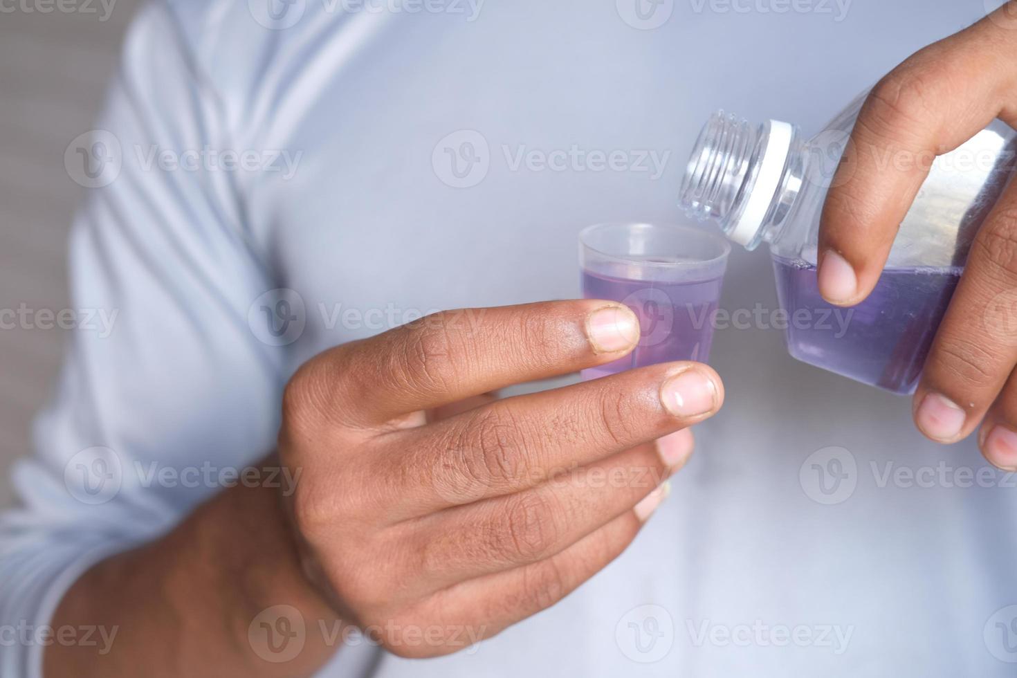 liquide de bain de bouche s'écoulant dans un bouchon photo