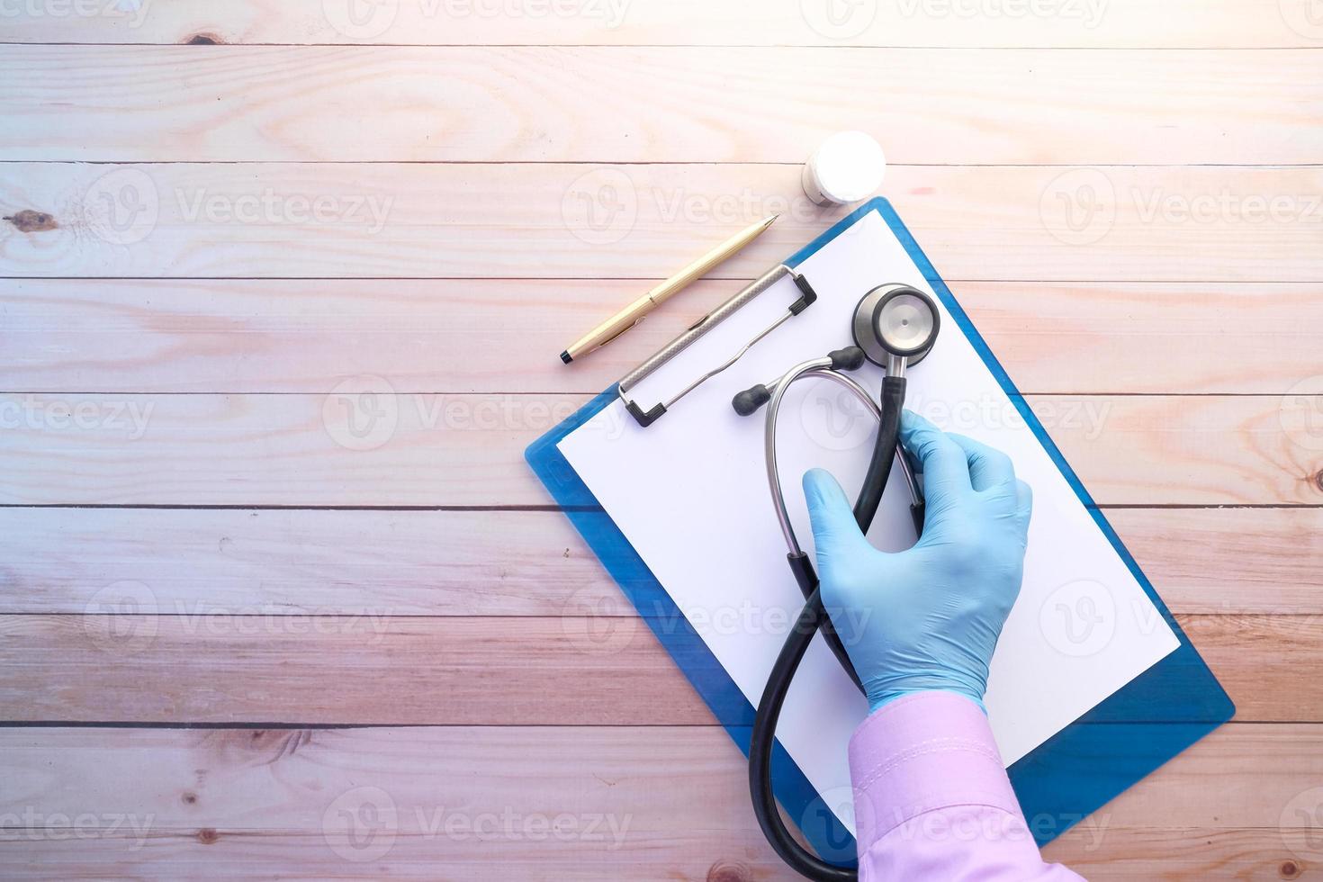 main du médecin dans des gants tenant un stéthoscope photo