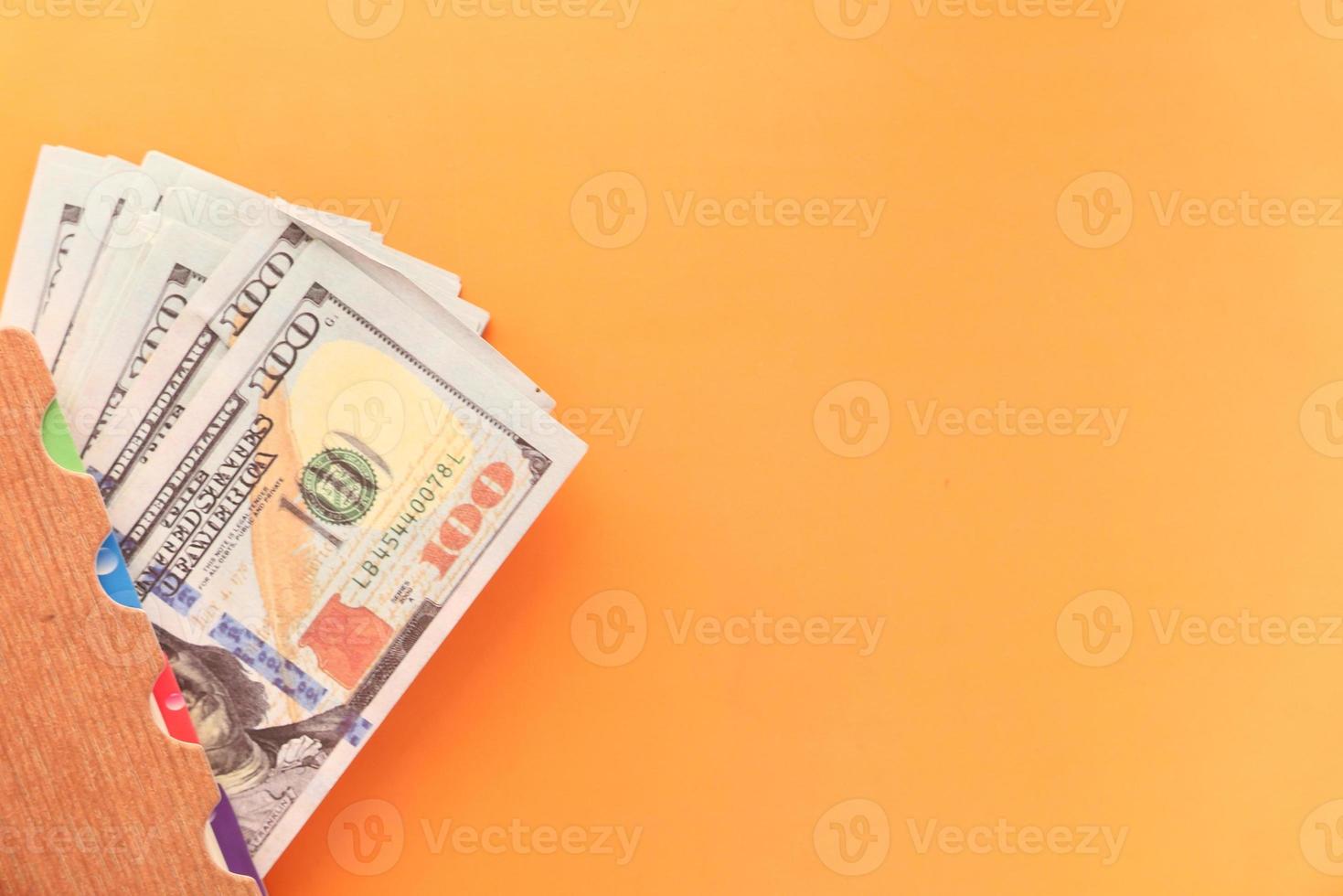 Gros plan de 100 dollars en espèces sur fond orange photo