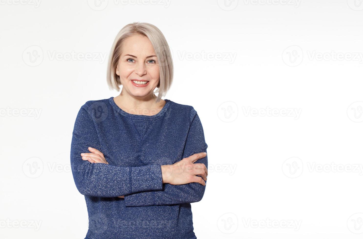 Jolie femme d'âge moyen avec les bras croisés sur fond blanc photo