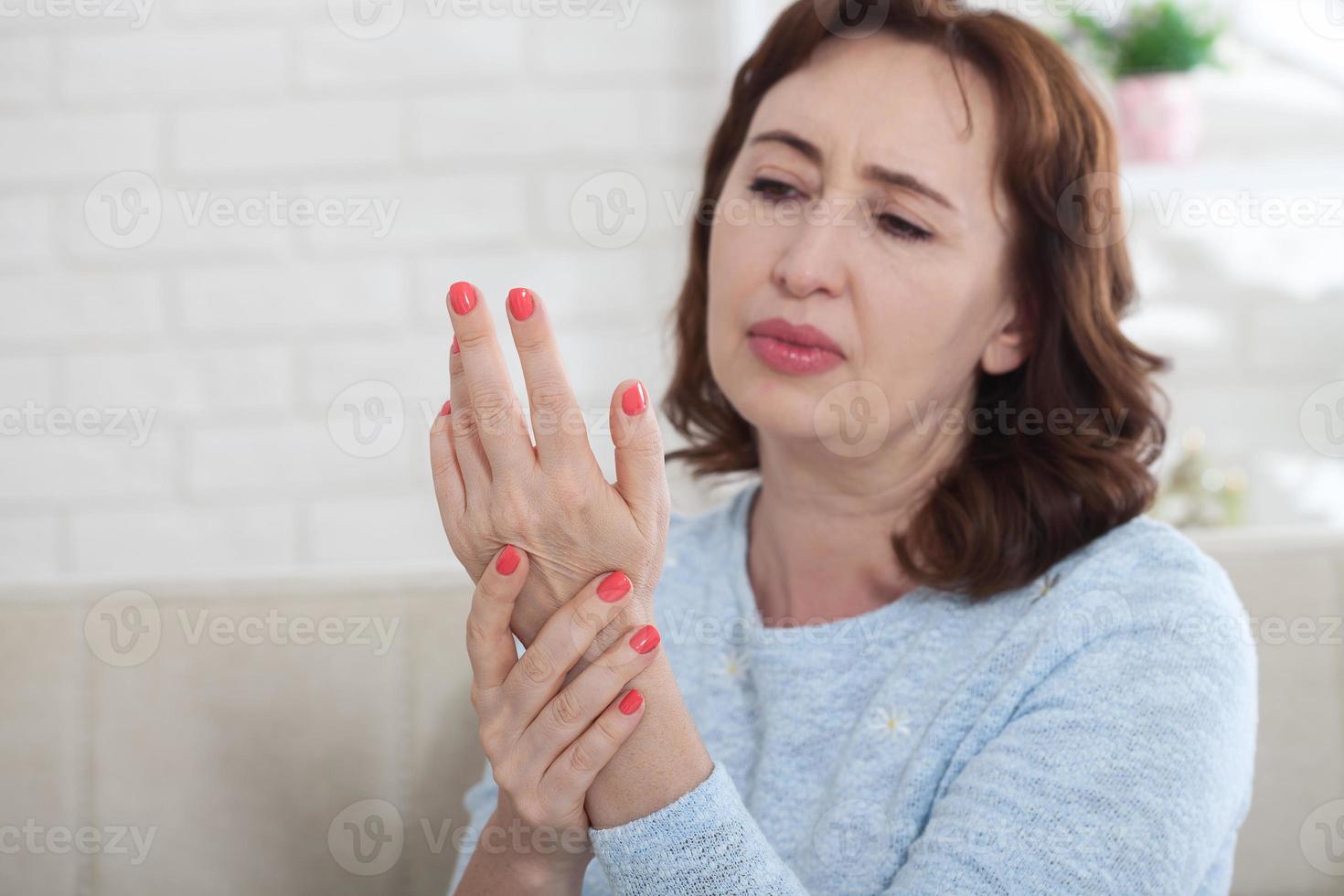 Sénior femme Souffrance de douleur dans le les articulations de le main à ho photo