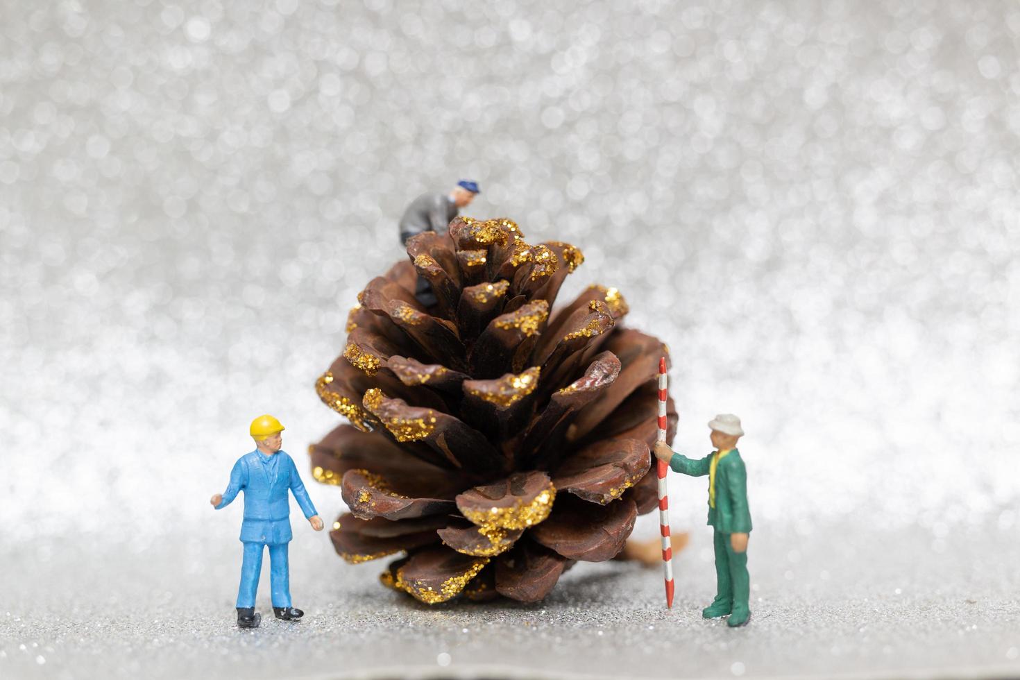 travailleurs miniatures préparant une pomme de pin de Noël, Noël et bonne année concept photo