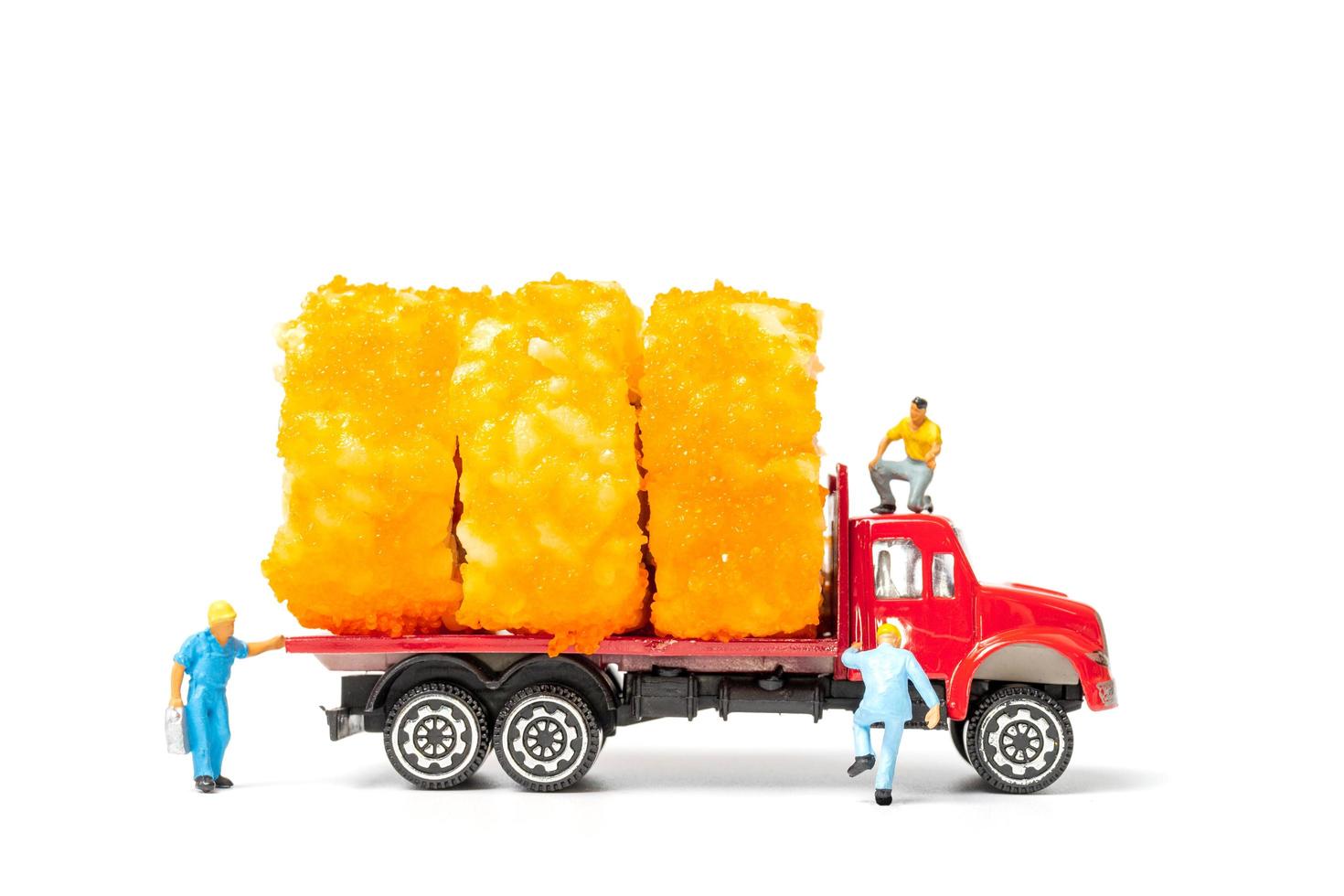 Personnes miniatures avec des rouleaux de sushi sur un camion isolé sur fond blanc, concept de livraison de nourriture photo