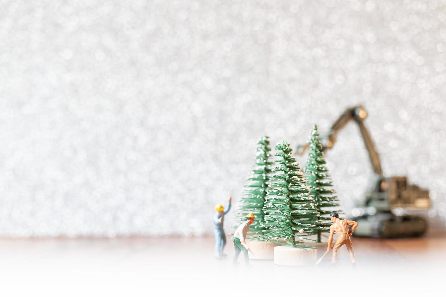 Groupe de travailleurs miniatures préparant un arbre de Noël, concept de décorations de Noël photo